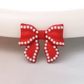 Macro shot of a red bow charm with white pearl border detail for DIY accessories - Red