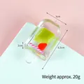 Green fruit popsicle keychain made of transparent acrylic with pink striped straw detail - Konjac
