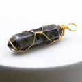Detailed macro view of crystal hexagonal pendant wrapped in handcrafted gold wire - Larvikite