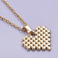 Close-up of golden heart pendant with beaded texture and elegant chain on purple background - Gold Necklace