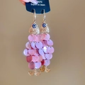 Detalle macro de pendientes de pez con lentejuelas moradas y gancho de metal oro - Ganchos para la Oreja con Forma de Pez Rosa