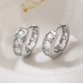 Elegante 18K vergulde oorringen met drie zirkoonstenen in een witte tray display - Zilver