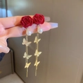 Detail showing red flocked rose and long gold butterfly tassel earring on hand - Red Flocked Flower Butterfly Pearl Tassel