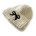 Cozy cream knit beanie for children featuring a large black bow embroidery detail - Beige