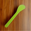 Vibrant bright green plastic facial mask mixing stick on a textured brown wood background - Pack of 100 / Transparent Green