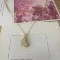 Gold layered initial necklace featuring a sparkling crystal heart pendant on beaded chain - Letter L