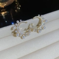 Dettaglio degli orecchini a mezzaluna dorati con zirconi pavé e piccole perle - Oro