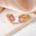 Nahaufnahme der goldenen Huggie-Ohrringe mit rosafarbenem Zirkon und Milgrain-Verzierung - Quadratisch / Rosa quadratischer Zirkonia
