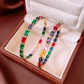 Macro shot of gold hoop earrings with baguette-cut rainbow gemstones in a leather box - Gold Style (Silver Pin)
