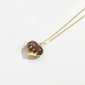 Gold necklace with a creative melting chocolate heart pendant on white background - Brown