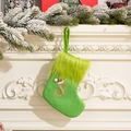 Green knit Christmas stocking with furry cuff and gold sequined letter S hanging on fireplace - Letter S