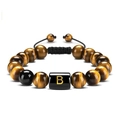 Macro detail of natural tiger eye and black onyx beads with golden letter B charm - Letter B