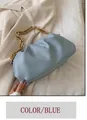 Sac pochette bleu clair chic avec chaîne dorée épaisse sur un blazer blanc cassé - Bleu