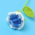 Nahaufnahme einer handgefertigten Häkelrose in Blau mit feinen Strickdetails und Stiel - Verlauf Blau