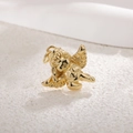 Macro shot of gold-plated cupid angel pendant with smooth metallic texture on textured surface - Angel 3
