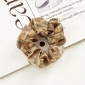 Brown leopard print scrunchie made of shiny fabric on a magazine for a stylish bun look - Brown Leopard