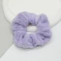 Macro shot of soft lavender plush faux rabbit fur scrunchie on a white geometric tray - Purple