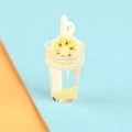 Detailed close-up of a miniature yellow fruit smoothie cup with a kiwi slice and straw - Banana