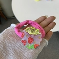 Detalle de una goma de pelo rosa con pieza acrílica y motivos de tulipanes rojos - Rosa del Principito