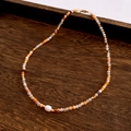Detail of beaded necklace with a large baroque pearl and warm-toned natural stones - Necklace / Yellow