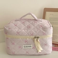 Close-up of pink quilted makeup bag with ribbon bow patterns and soft fabric texture - Pink Ribbon Bowknot Makeup Bag