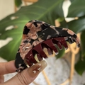 Dettaglio del fermaglio per capelli tartarugato con logo dorato e denti a pettine rossi - Rosa Nero - Etichetta Oro Triangolo