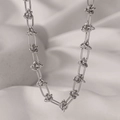 Detailed close-up of a silver long oval link necklace with elegant knot fasteners - H194 Thorn Chain Silver Necklace
