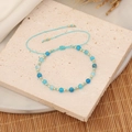 Détail macro de perles bleues et bracelet tissé ajustable sur une surface en pierre - Bleu lac