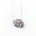 Macro detail of raw purple crystal stone pendant with natural texture on silver chain - India Agate