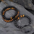 Three-piece tiger eye and volcanic stone beaded bracelet set on dark textured rock - 6mm Matte Black Tiger Eye + 8mm Volcanic Tiger Eye Set