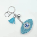 Detailaufnahme des blauen Evil Eye Schlüsselanhängers mit Strasssteinen und Quaste - Seeblau