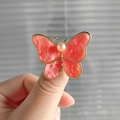 Macro detail of butterfly brooch with pink marble texture wings and pearl center - Coral Butterfly