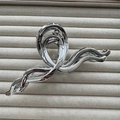 Macro shot of silver metallic hair claw clip with sleek streamlined twisted design - Double Figure Silver 13cm