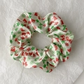 Detailed close-up of cream satin scrunchie with festive Christmas tree and hat patterns - Style 8 (Cream Red Green Christmas Hat)