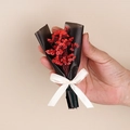Close-up of mini dried red flower bouquet wrapped in black paper with a beige ribbon - Style 03 Red Crystal Grass Bouquet