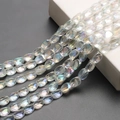 Dettaglio macro di perle di cristallo iridescenti 10x12mm con finitura arcobaleno per fai da te - Bianco AB
