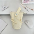 Detail of macaron color foldable pencil case with bow tie and blue button handle - Beige