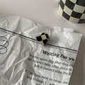 Detailed view of heart-shaped black and white checkered earring on vintage newspaper - 1# Mini Hair Claw - Heart