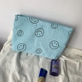 Detail of light blue corduroy pouch featuring black smile patterns and striped texture - Sky Blue Smiley Face Storage Bag