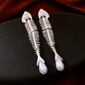 Detalle de pendientes de espina de pescado plateados con perla de gota en fondo negro - Pin de Plata Perla Blanca Estilo Espina de Pescado