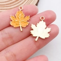 Detail showing orange enamel maple leaf charms with gold-plated metal veins and smooth back - Maple Leaf