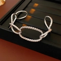 Macro shot of silver-tone hollow chain bracelet with twisted spiral texture on leather - Plated Bracelet / Silver