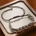 Close-up of vintage hand-woven brown bracelet with silver flower beads and ethnic style - 3 Small Flowers Bracelet