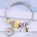 Adjustable steel wire bracelet featuring yellow honeybee, heart charms, and pearls - Yellow