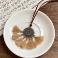 Gros plan détaillé du collier bohème avec pompons kaki et pendentif floral en métal - Style 2-Rond Marron Clair Pompon