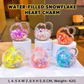 Set of colorful liquid oil heart-shaped keychains with snowflakes on white display stands - 1 Piece / Snowflake Heart Lock