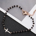 Dettaglio del ciondolo a croce in oro rosa su bracciale a perline nere con chiusura - Argento Croce