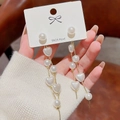 Close-up of S925 silver needle drop earrings with white heart-shaped pearl tassels - Gold Heart Pearl Tassel