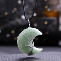 Macro shot of a green crescent stone moon pendant wrapped in silver wire tree of life pattern - Green Aventurine