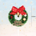 Detailed view of a 6.5cm mini green Christmas wreath cake topper with red bow and gold bell - Glitter Pentagram Decor Wreath Style